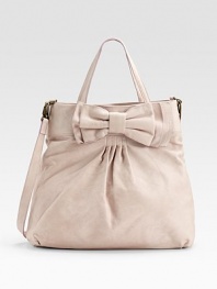 Soft, buttery leather, crafted in a slightly slouchy silhouette with a chic bow accent.Double top handles, 6½ drop Removable shoulder strap, 21 drop Snap top closure One inside zip pocket Cotton lining 18W X 15H X 4D Imported