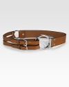 Rich vachetta leather styled with two buckle straps on one side, one wide strap on the other and a bold silver ring in the middle. Silvertone buckle About 1¾ wide Leather Imported