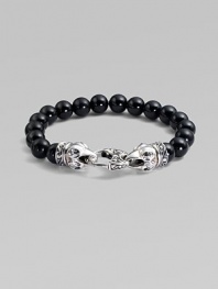 A strand of smooth black onyx beads, capped by dramatic carved raven's heads of sterling silver, clutching the clasp in their beaks. Black onyx Sterling silver Length, about 9¼ Lobster clasp Imported