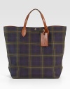 A handsome tote in a heritage-rich tartan plaid canvas, finished with supple calfskin trim and custom-made brass hardware. Snap closure Top handle Leather ID tag Interior pockets Fully lined 15¼W X 20H X 5D Imported 