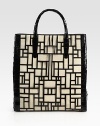 Rich snake-skin with geometric cut-outs layer over woven raffia for a modern look.Double top handles, 5 dropMagnetic closureProtective metal feetCenter zip compartmentOne inside zip pocketTwo inside cell phone pocketsSuede lining14W X 15¼H X 4DImported