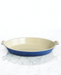 Capture the excellence of French cuisine with a refined dish that features a flat, shallow design and classic scalloped handles. Constructed of cast iron, this piece conducts and retains heat for a savory dish every time. 5-year limited warranty.