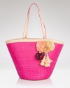 Give looks a rah-rah-resort-inspired spin with this straw tote from Juicy Couture. Playful pom-poms and a punchy hue make this a cheery vacation companion.