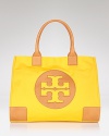 Make Tory Burch's signature coated canvas tote your day-to-day choice. Sized for the essentials, the brightly hued style adds polish to daytime denim and basics.