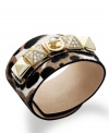 This edgy cuff bracelet from Juicy Couture features a gold tone brass plaque with a crown logo and pyramid studs embellished with glass stones. Crafted from printed calf hair leather. Approximate length: 9 inches. Approximate diameter: 2 inches.