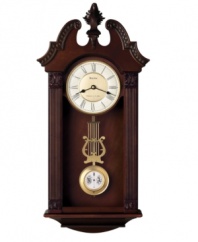 Stunning sophistication. Intricately carved, this walnut-finished wooden wall clock by Bulova features a gorgeous pendulum and plays Westminster or Wittington chimes on the quarter hour. Two-tone metal dial with Roman numerals and two hands features adjustable volume control and night shut-off.