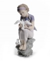 Experience tranquility. Perched on a rock embracing the simple joys in life, a graceful young lady studies the beauty and purity of visiting doves. A peaceful reminder to slow down and study the brilliant details in life, by Lladro.