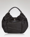 Salvatore Ferragamo makes a casual statement with this spacious nylon hobo. Dressed up in a pretty bow and leather trims, the bag will easily accommodate all your essentials.