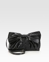 A feminine design of dotted velor on faux leather, topped off with a front bow and shiny patent leather strap. Adjustable patent leather shoulder strap, 23½-25 dropMagnetic flap closureOne inside zip pocketCotton lining11½W X 7½H X 1½DMade in Italy